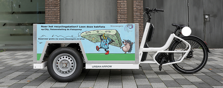 Bakfiets met tekst op de bak: Naar het recyclingstation? Leen deze bakfiets op City, fietsenstalling De Fietspomp